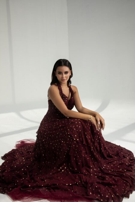 فستان سهرة برغندي بتفاصيل ذهبية براقة